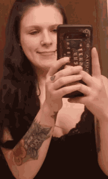 a woman is taking a picture of herself in a mirror with a phone case that says ' ainuo ' on it