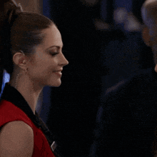 a woman in a red top is talking to another woman in a black top