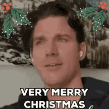 a man says very merry christmas in front of a picture of a snowy mountain