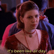 a woman says it 's been like all day while wearing a red dress