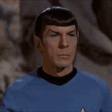 the man is wearing a blue shirt and waving his hand .