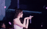 a woman in a white dress is singing into a microphone on stage