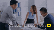 a group of people are gathered around a table with the words welcome to bitcoin core above them