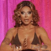 a woman with a surprised look on her face is wearing a gold top