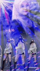 three women wearing masks are dancing in front of a woman wearing a hijab .