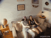 two women sitting on a couch with a gifrun.com watermark in the corner