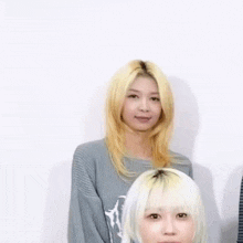 a woman with blonde hair is smiling while standing next to another woman .