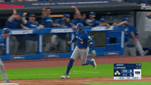a blue jays baseball player runs to home plate