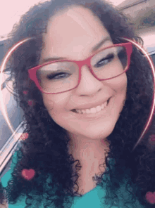 a woman with curly hair and glasses is smiling