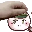 a hand is putting a hat on a cartoon face .