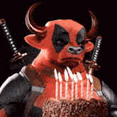a bull with horns is holding a birthday cake with lit candles