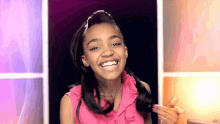 a young girl wearing a pink top and a necklace smiles