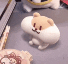a stuffed animal is sitting on a table next to a lion badge .