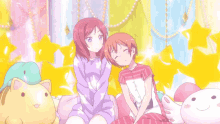 two anime girls are sitting next to each other with a cat on their head