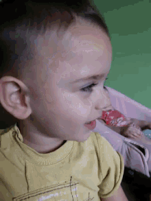 a little boy wearing a yellow shirt has a yellow spot on his face