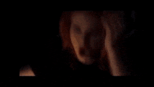 a person is holding a light bulb in a dark room .