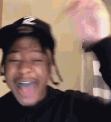 a man wearing a hat is making a funny face with his tongue out .