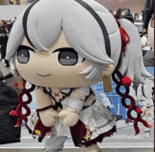 a stuffed doll with gray hair and red flowers in her hair is standing on a bench .