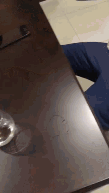 a person is sitting at a table with a glass of water on it