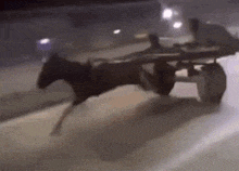 a horse drawn carriage is going down a street at night