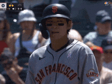 a baseball player wearing a san francisco giants jersey stands in front of a crowd
