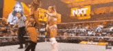 two women are wrestling in a ring with a sign that says nxt in the background .