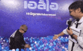 a man playing in a ball pit with a sign that says ' ioala ' on it