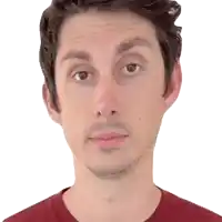 a man with a beard and a red shirt looks at the camera