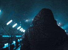 a person in a hooded jacket is walking through a tunnel