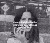 a black and white photo of a woman talking on a cell phone with a sign that says end