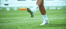 a soccer player is kicking a soccer ball on the field .
