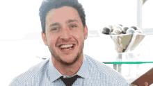 a man with a beard is smiling in front of a bowl of balls