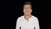 a man wearing glasses and a white shirt is making a face .