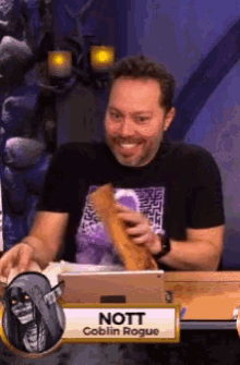 a man is sitting at a table with a name tag that says nott goblin rogue