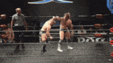 two men are wrestling in a ring with a sign that says dnc