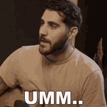 a man with a beard is holding a guitar and says " umm "
