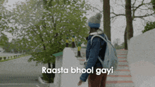 a woman with a backpack is walking down stairs with the words raasta bhool gayi written on the bottom