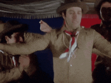 a man wearing a cowboy hat and tie is dancing