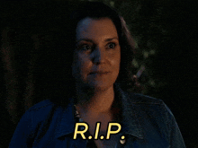 a woman in a denim jacket says r.i.p. in yellow