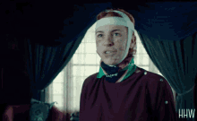 a woman with a bandage on her head has the letters hw on the bottom right