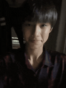 a young man wearing a plaid shirt is making a peace sign