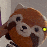 a stuffed animal with a yellow eye is being held by someone