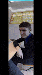 a man sits at a desk in front of a poster that says ' russian federation ' on it
