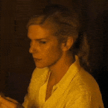 a close up of a woman 's face in a yellow shirt .