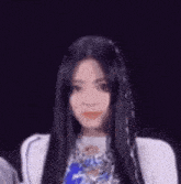 a close up of a woman with long black hair wearing a white shirt .