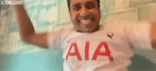 a man wearing a white shirt with aia written on it