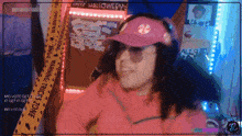 a woman wearing a pink hat and sunglasses stands in front of a caution tape that says halloween