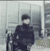 a man is standing in front of a building that says freecdn on the bottom
