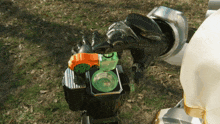 a robotic arm is holding a green object that looks like a bottle of liquid