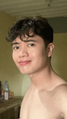 a young man without a shirt is taking a selfie
